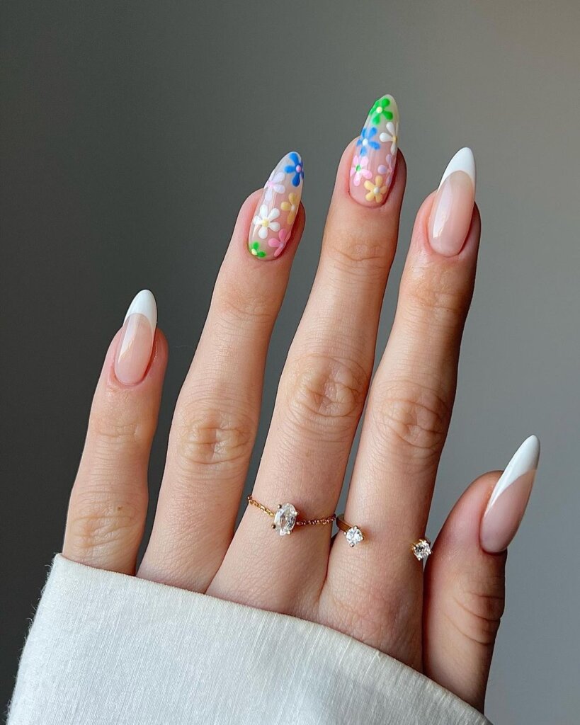 Almond-shaped nails with colorful floral accents on a neutral base.