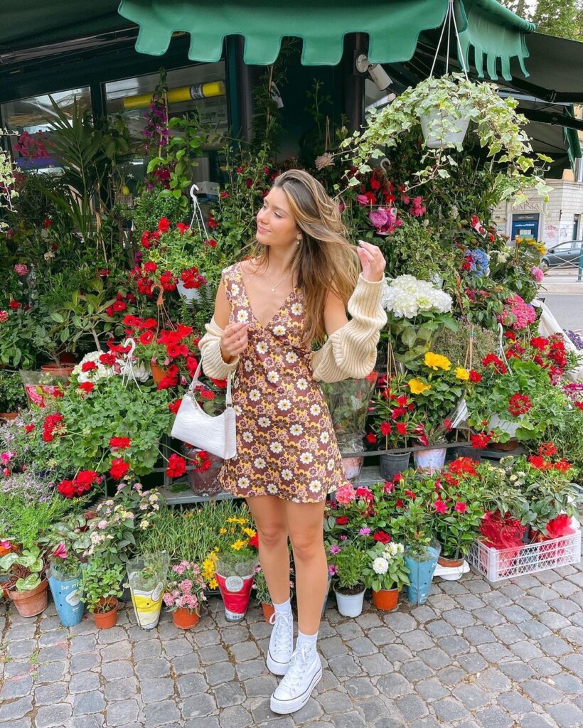 A floral mini dress paired with a cozy cardigan and neutral accessories, creating a charming and relaxed spring ensemble.