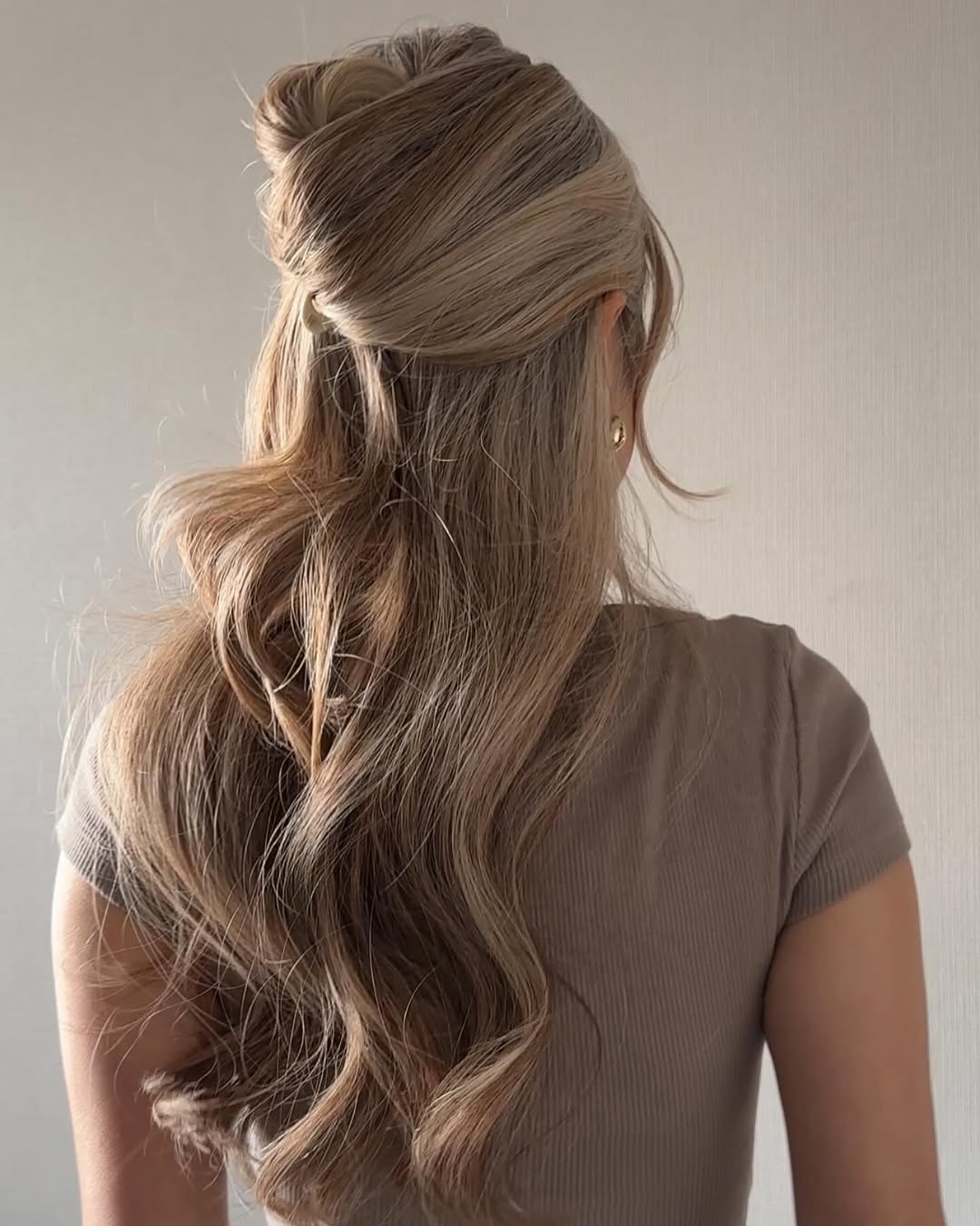 A half-up style with soft volume and loose waves.