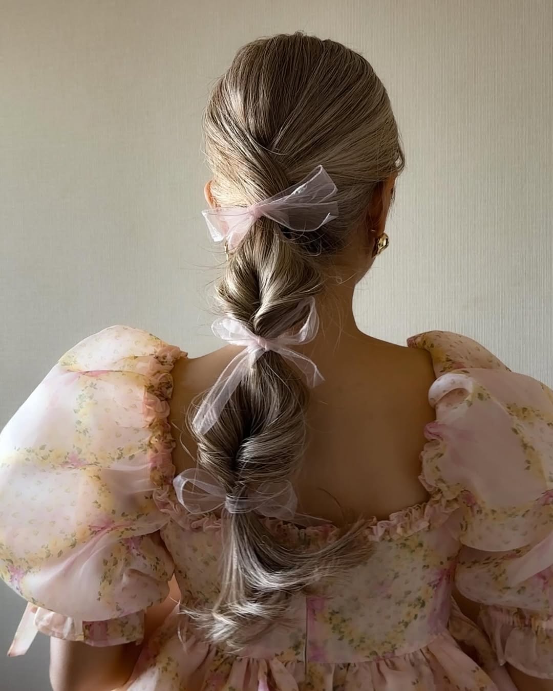 A bubble ponytail tied with a delicate ribbon.