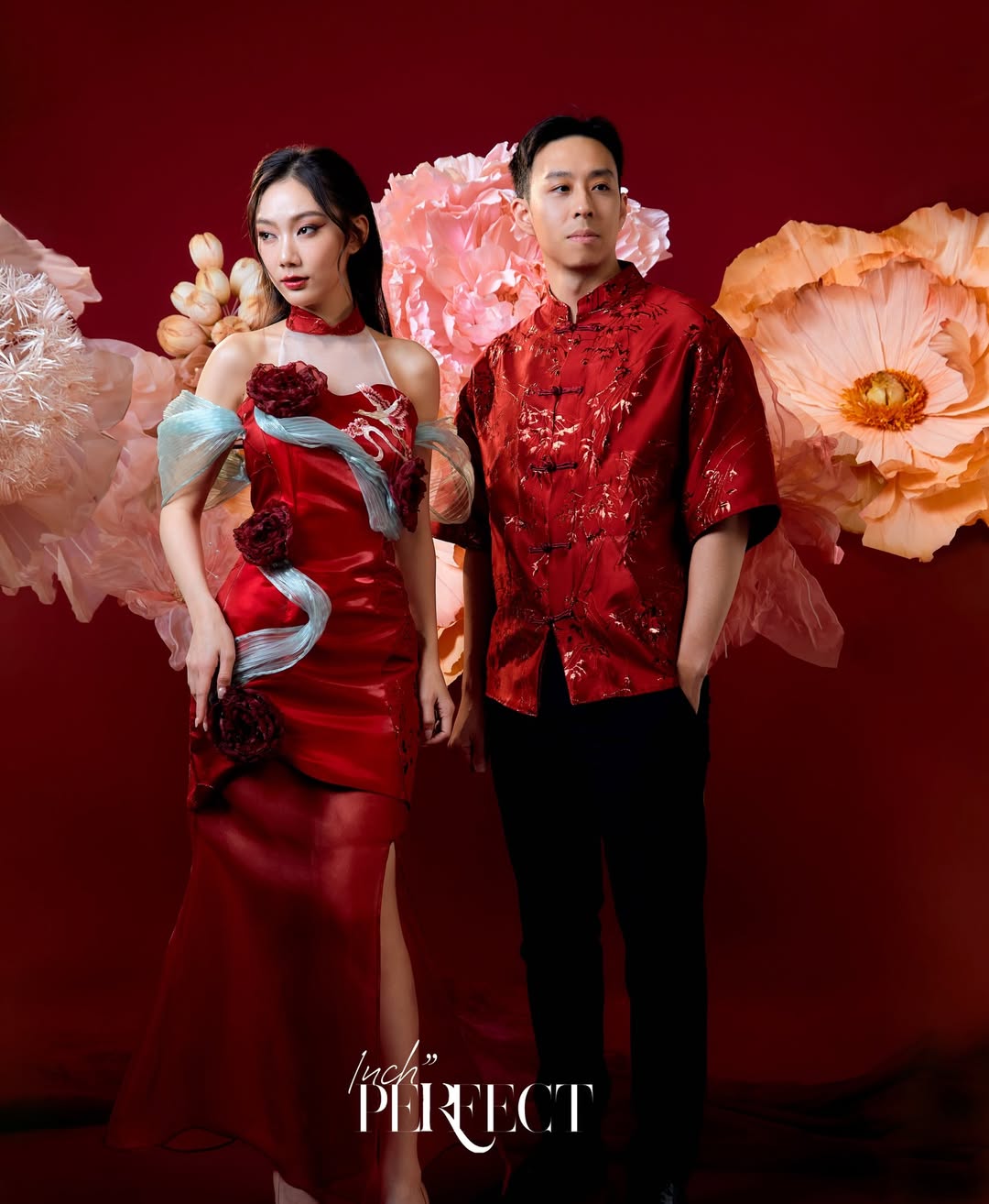 A striking red satin dress with floral appliqués and a dramatic silhouette, exuding confidence and celebratory elegance.