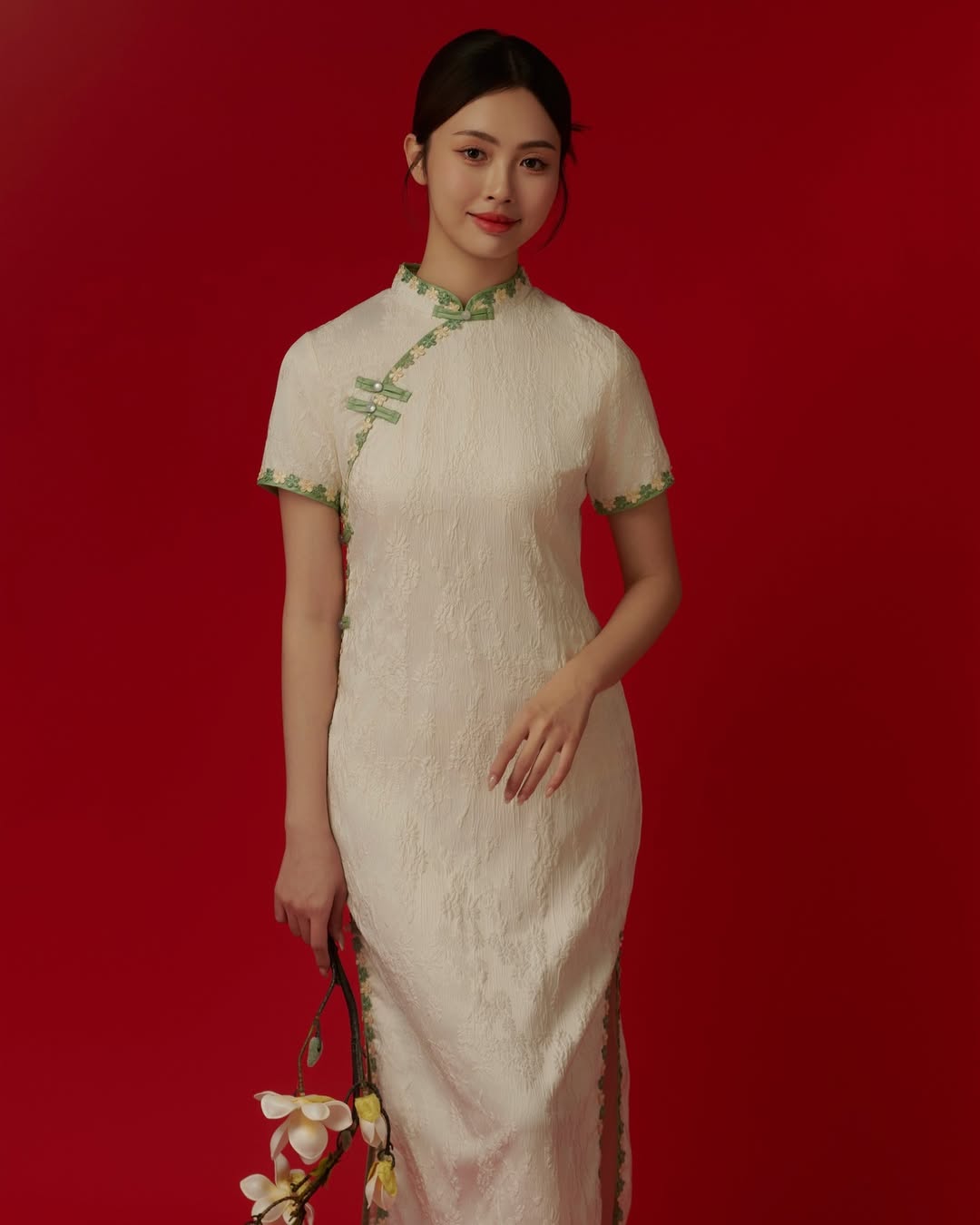 An elegant ivory dress with delicate green trim, showcasing soft grace and timeless appeal for Chinese New Year.