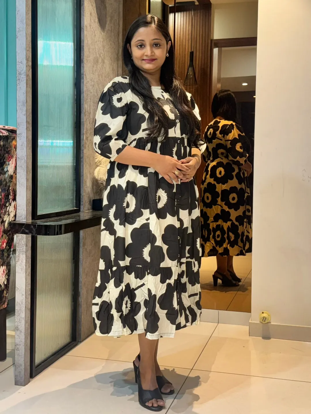 A black and white floral print maternity dress with a flowing silhouette.