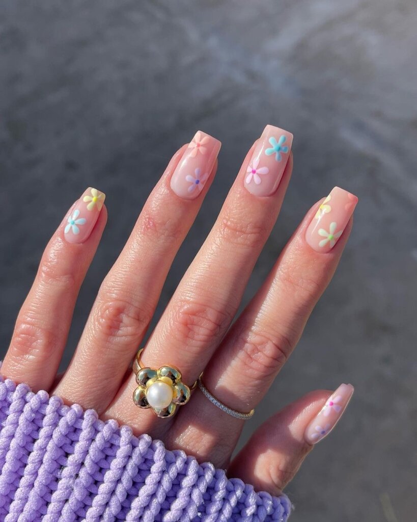 Sheer base nails with scattered tiny pastel flowers for a spring look.