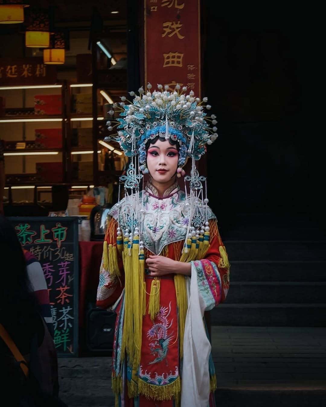 An elaborate outfit featuring ornate headwear and detailed embroidery, blending historical elements with a modern festival context.