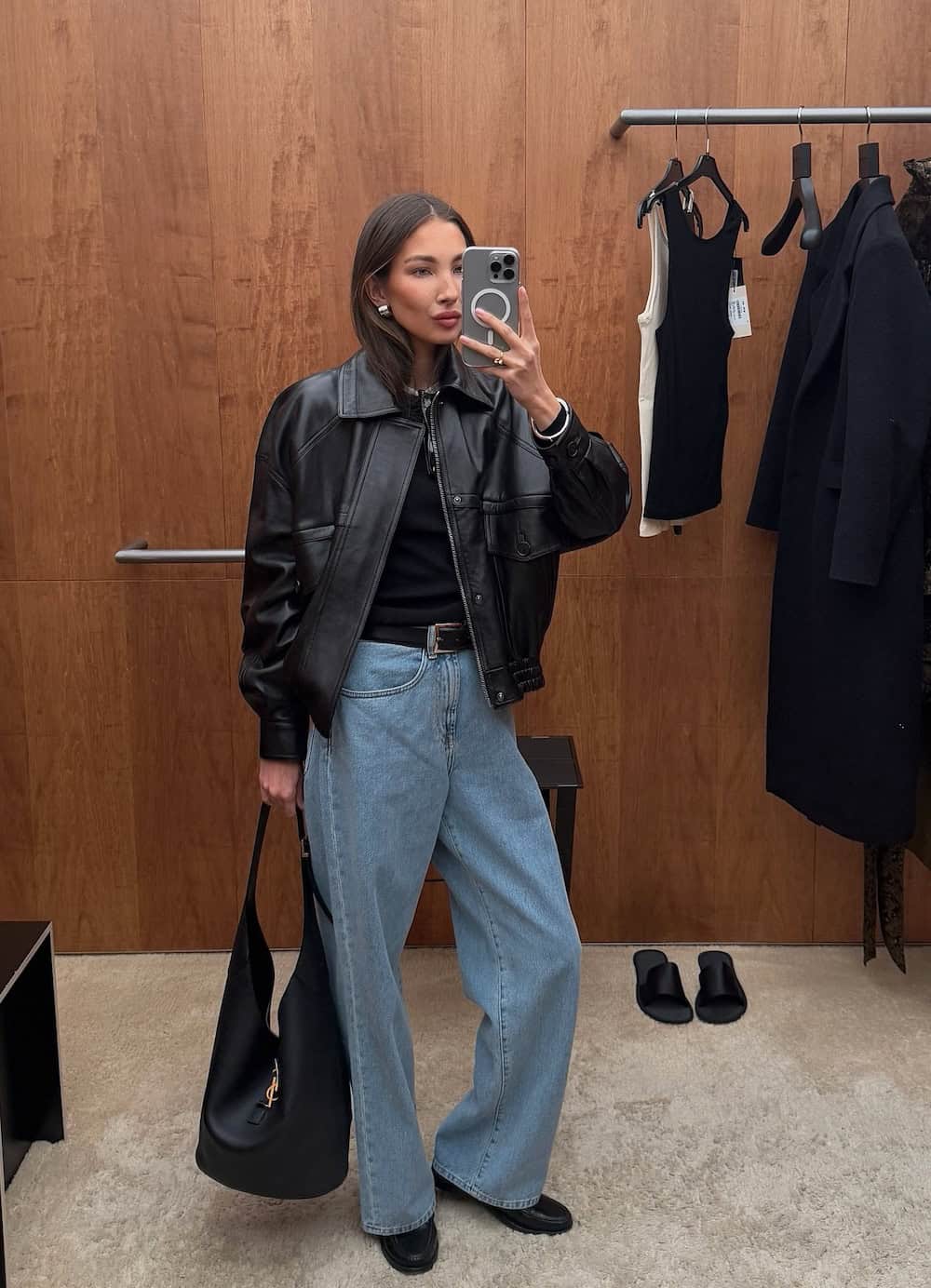 Woman wearing blue jeans, black t-shirt, and a leather jacket