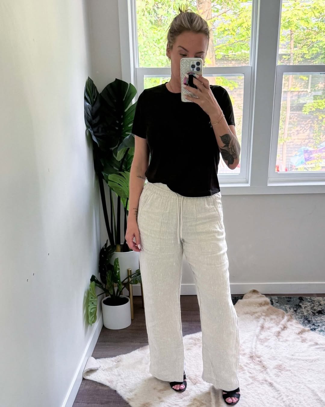 Woman wearing ivory linen pants with a black tee and relaxed drawstring waist.