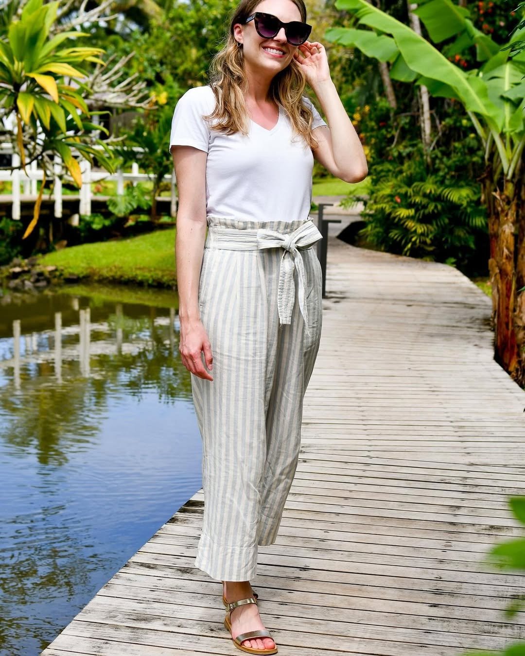 Woman wearing striped linen pants with a paper-bag waist and a white tee.
