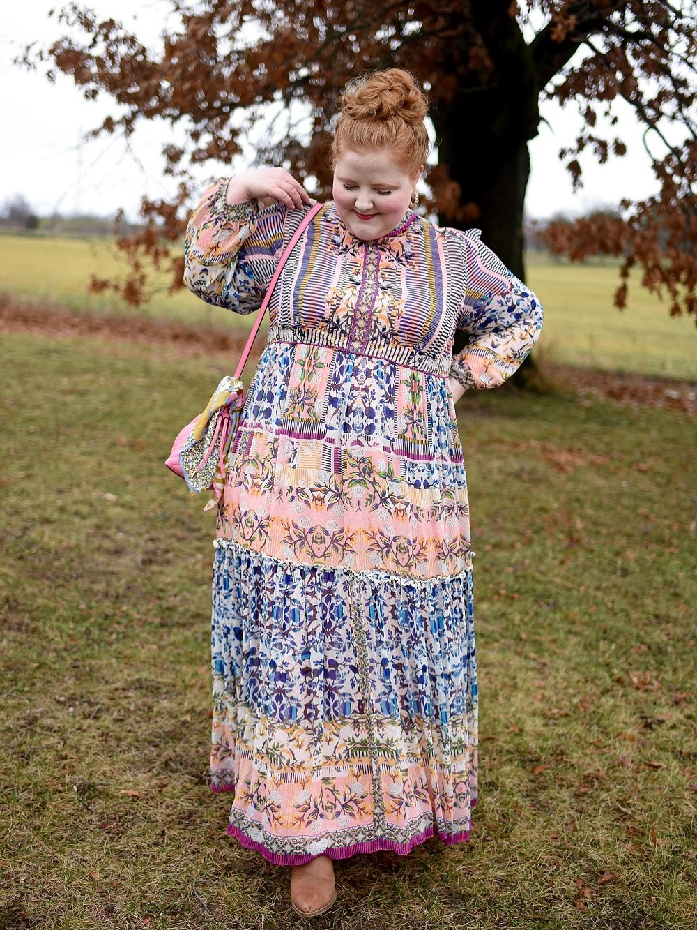 A tiered maxi dress featuring mixed prints, a relaxed silhouette, and boho-inspired styling.