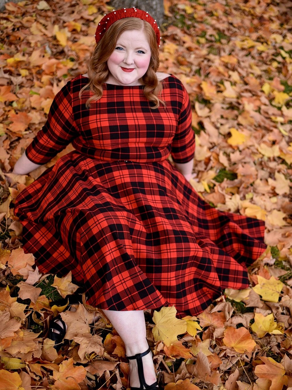 A red-and-black plaid midi dress in a fit-and-flare style, with a matching headband.