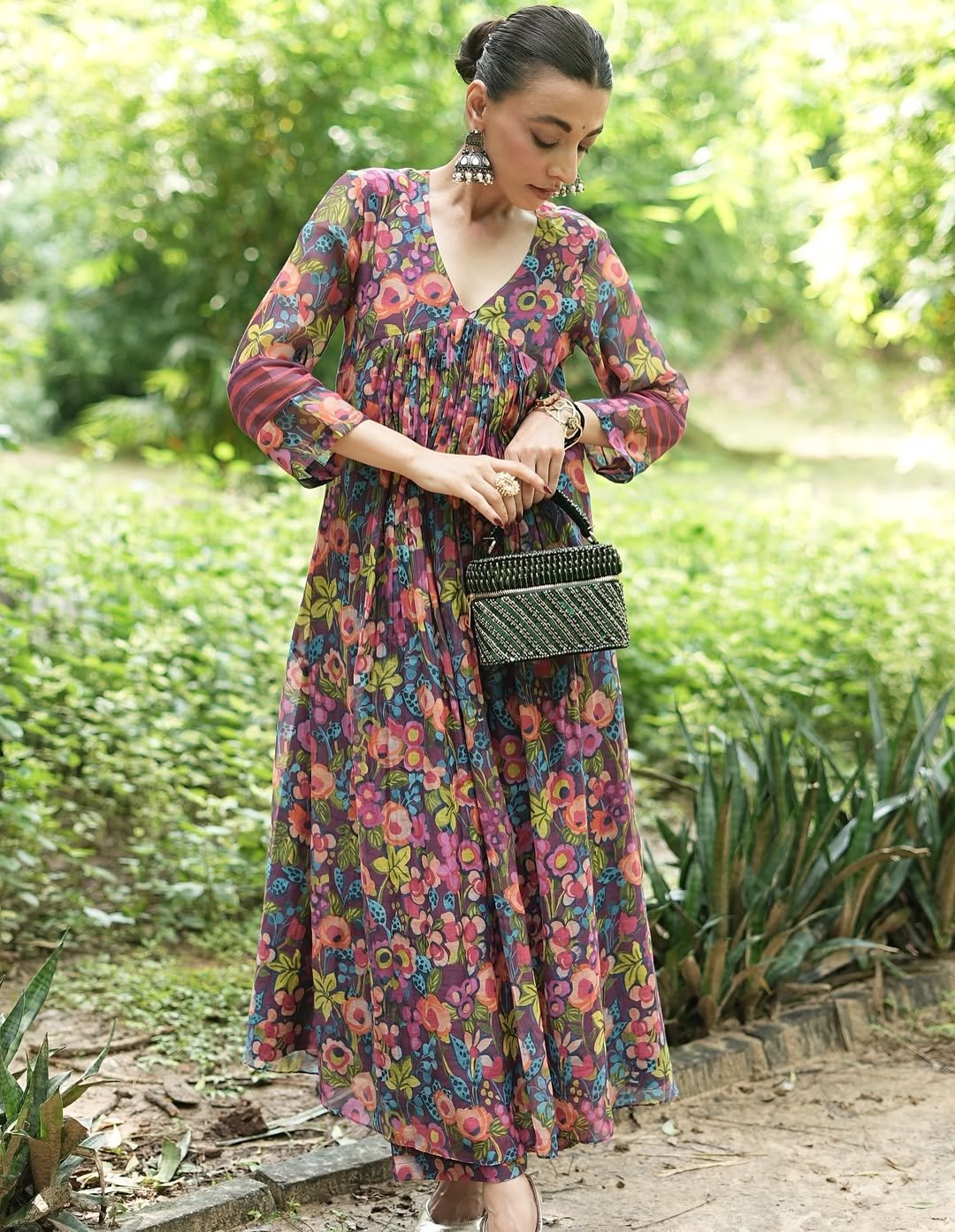 A printed long-sleeved dress with soft pleating and a flowy fabric, suitable for daytime events.