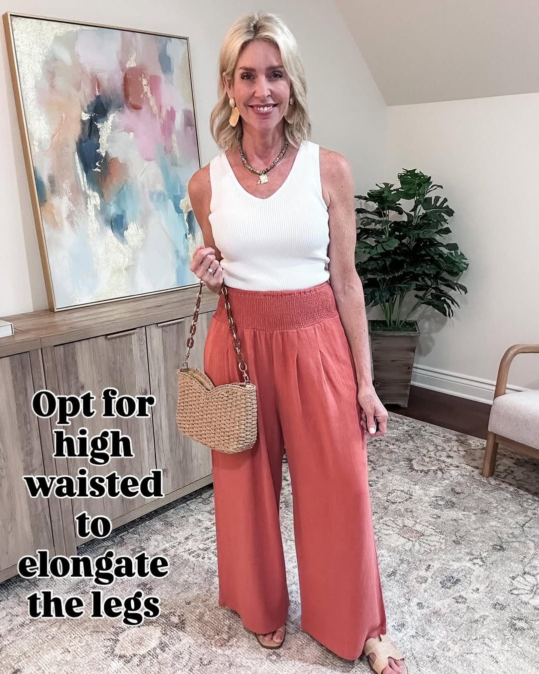 Woman wearing high-waisted coral linen pants with a ribbed neutral tank.