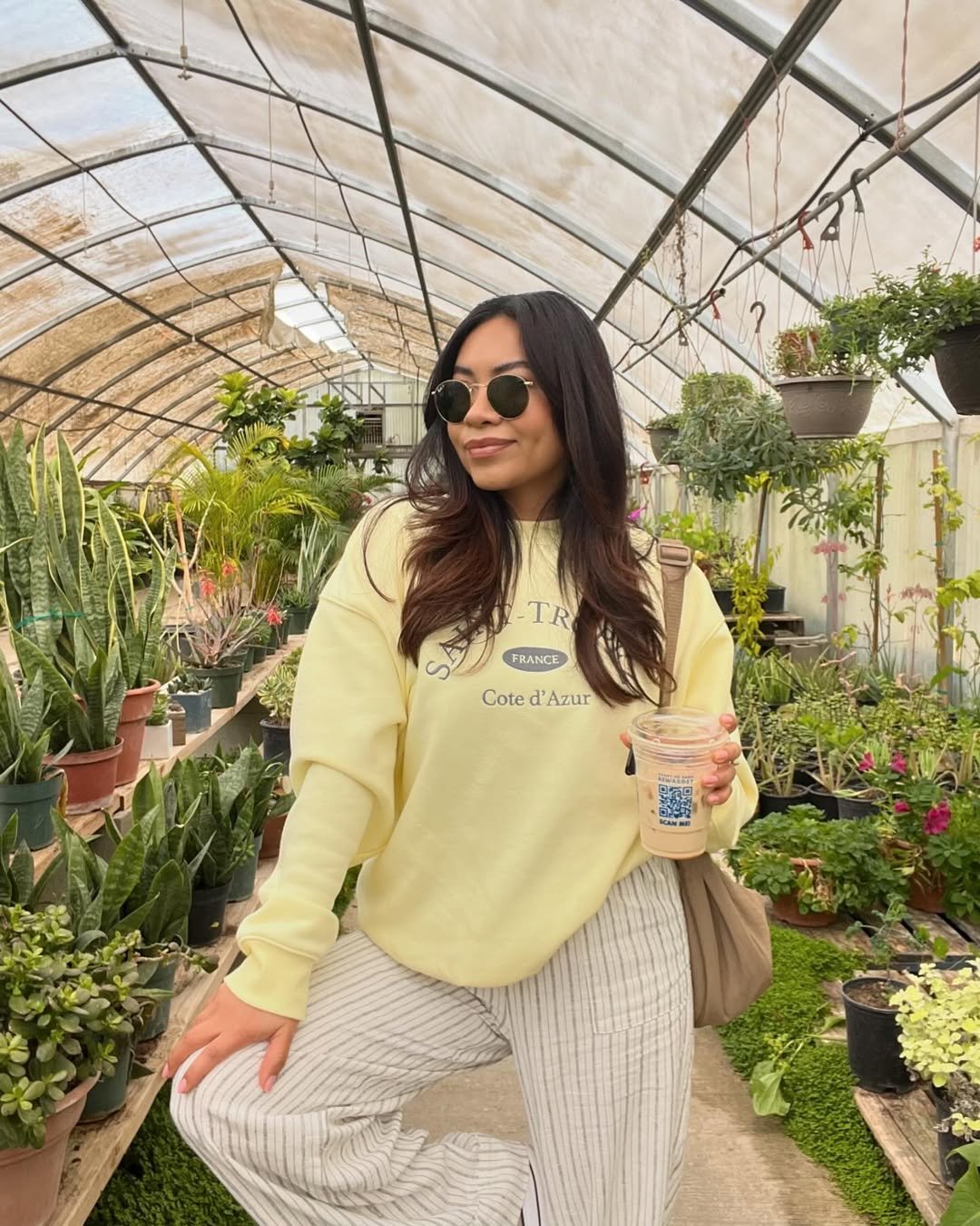 Woman wearing striped linen pants with a pale yellow sweatshirt.