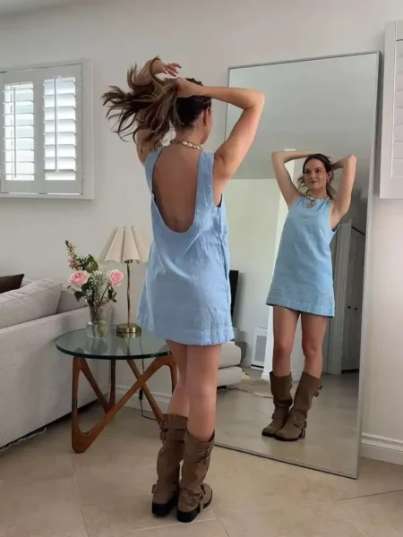 Woman in sky-blue linen dress and tan suede boots