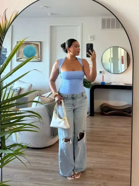 Woman in baby blue halter top and ripped jeans