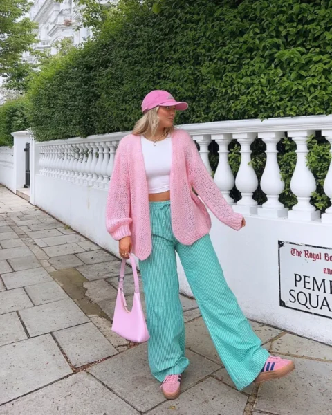 Woman in pink cardigan and mint green trousers in London