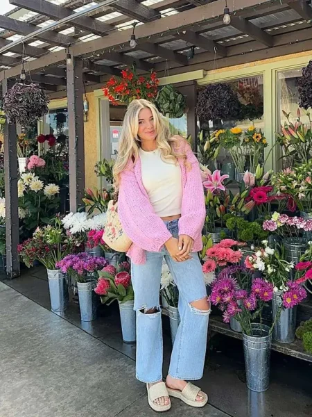 Woman in pink cardigan and jeans at a flower market