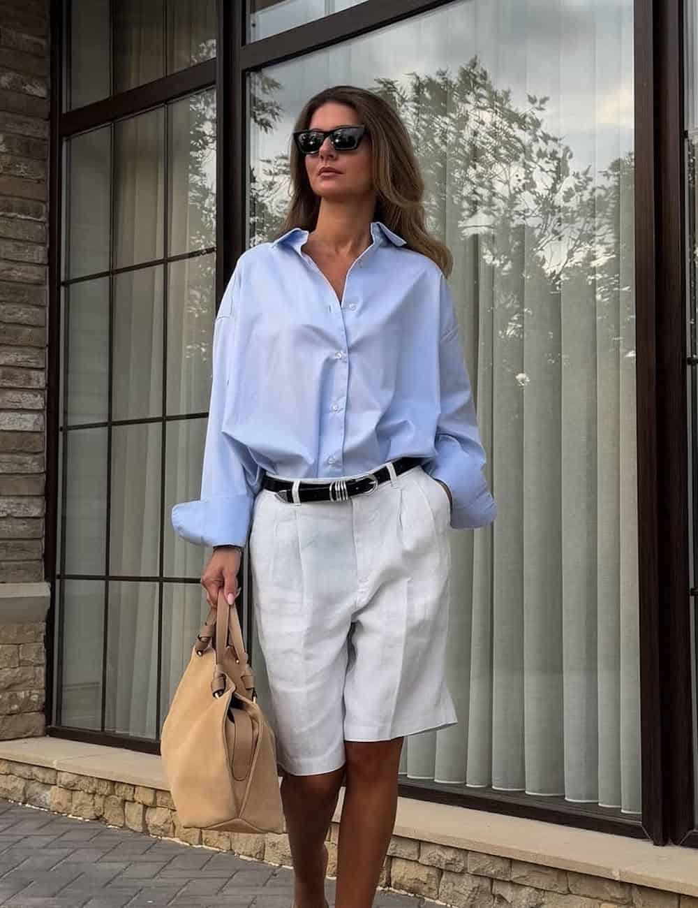 Woman wearing tailored Bermuda shorts with a button-up shirt