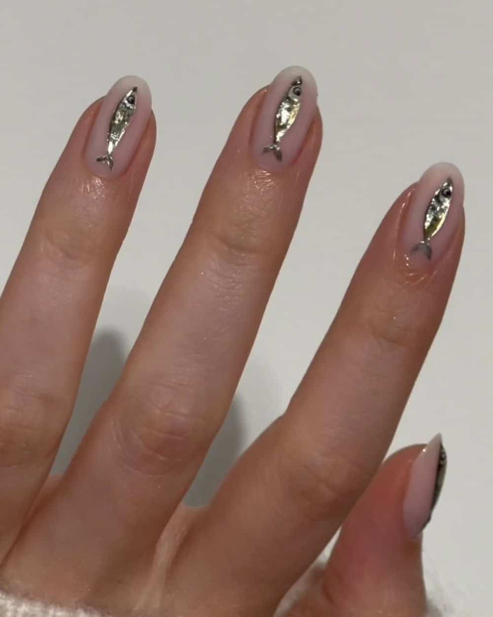 Neutral nails with tiny iridescent fish art