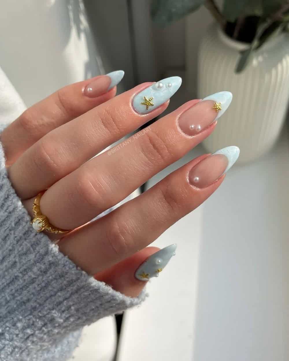 Pastel blue nails with pearls and gold charms