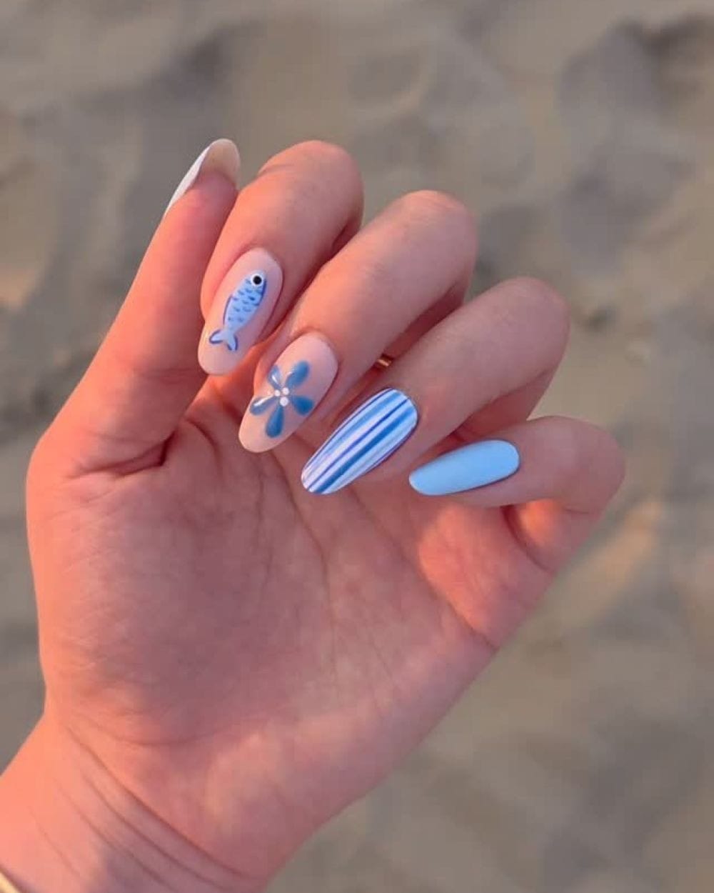 Blue striped and floral nails with fish motifs