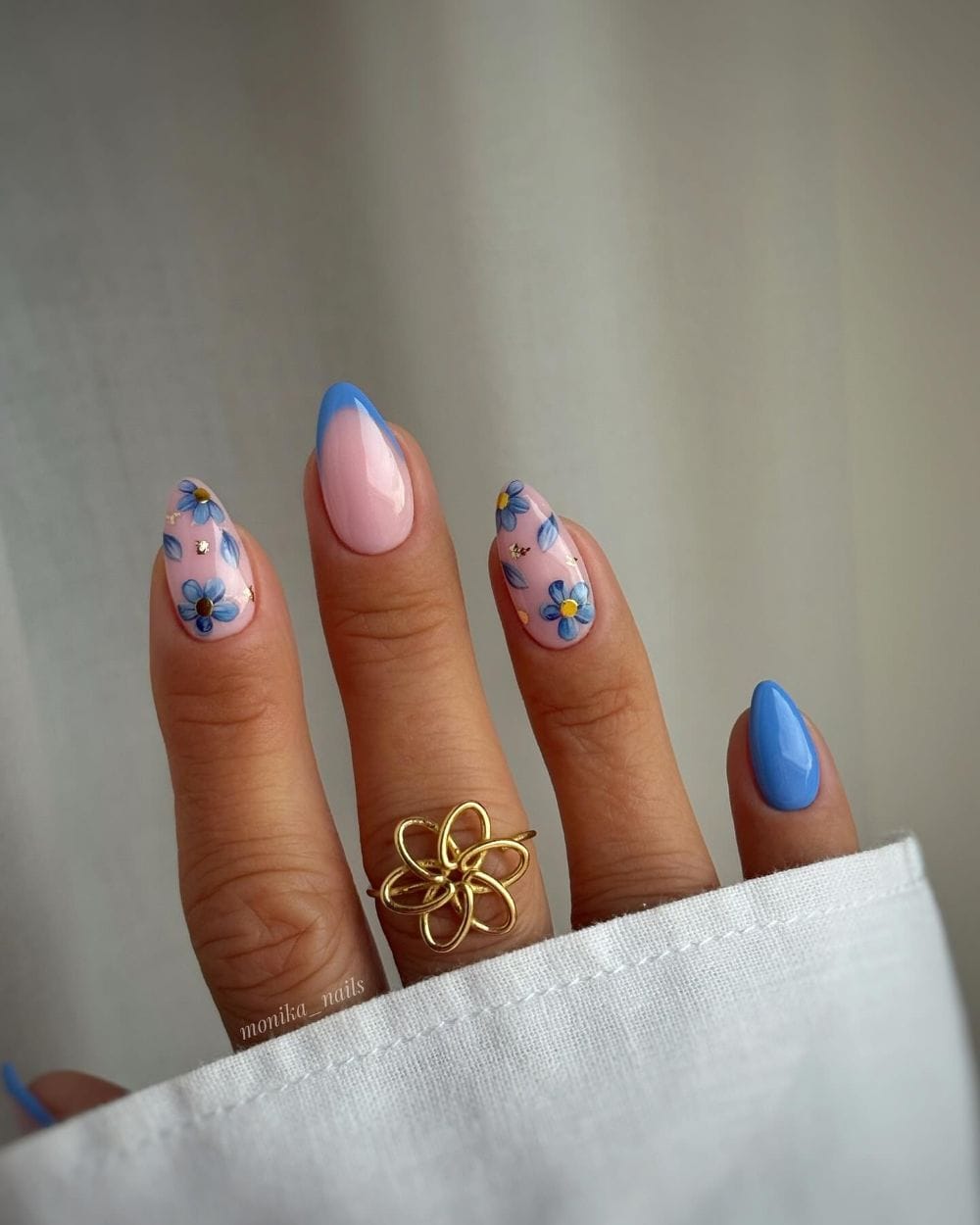 Floral nail art with gold accents on pink base