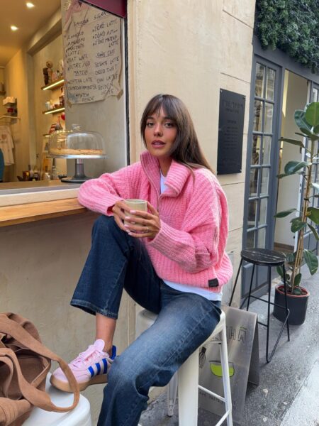 Pink knit sweater, denim, and sneakers.