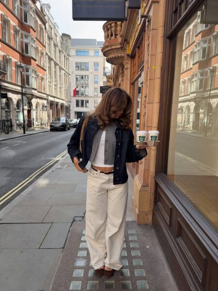 Denim coat, ivory slacks, and chestnut loafers.
