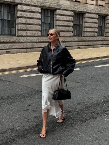 Black leather bomber, satin slip skirt, and flip-flops.