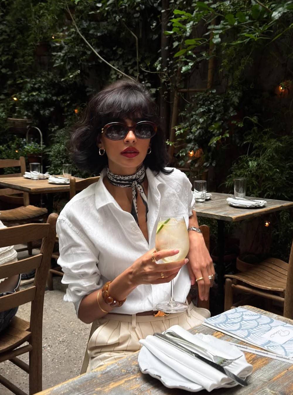 Woman styling a scarf around her neck