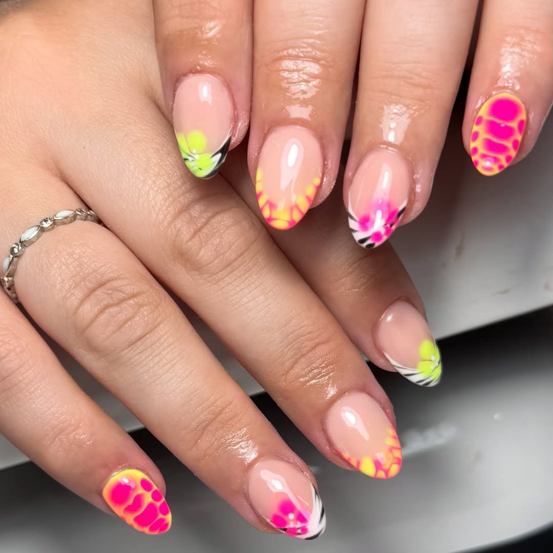 Nails with neon pink and yellow accents on a nude base