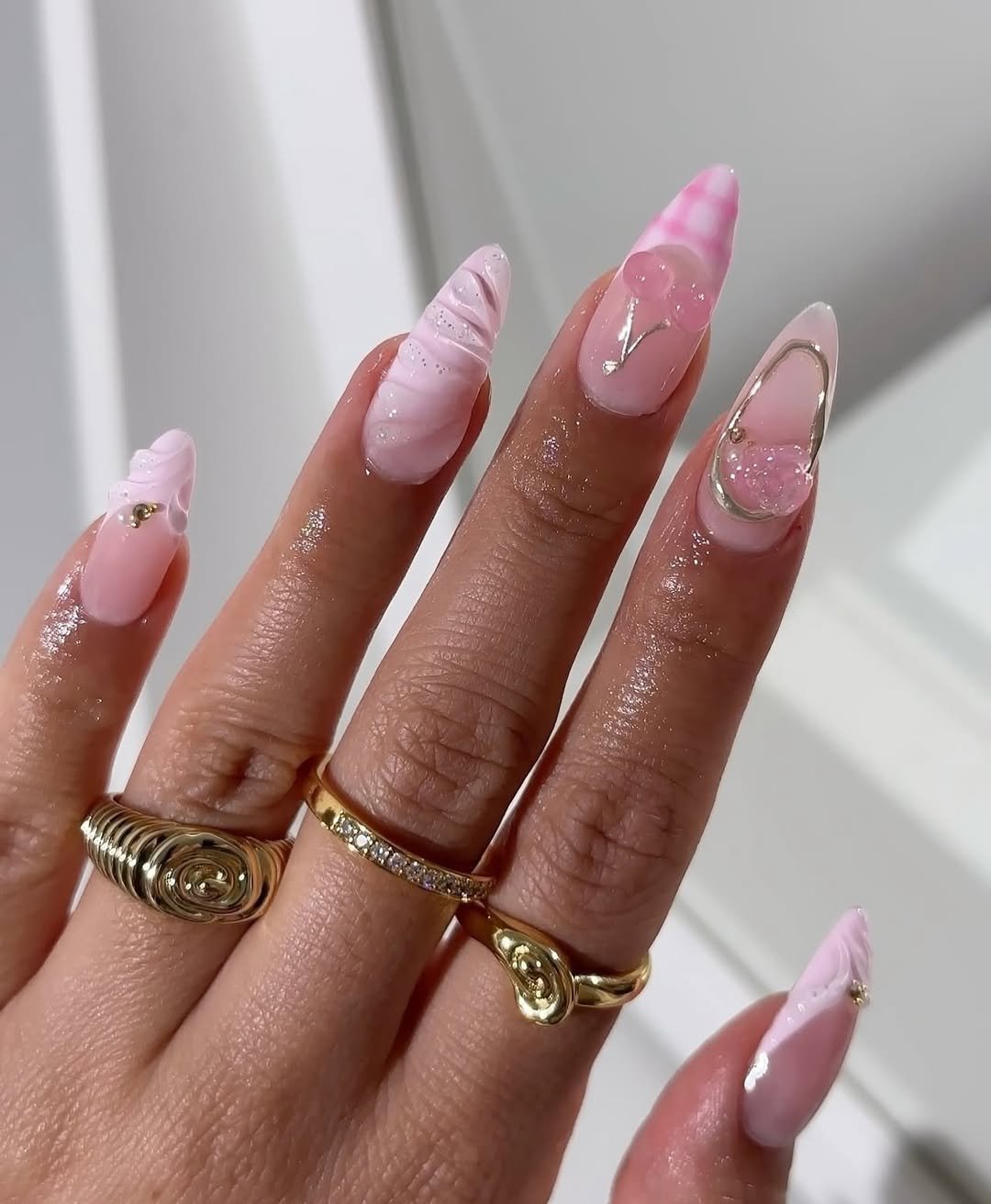 Glossy pink nails with floral accents and gold foil