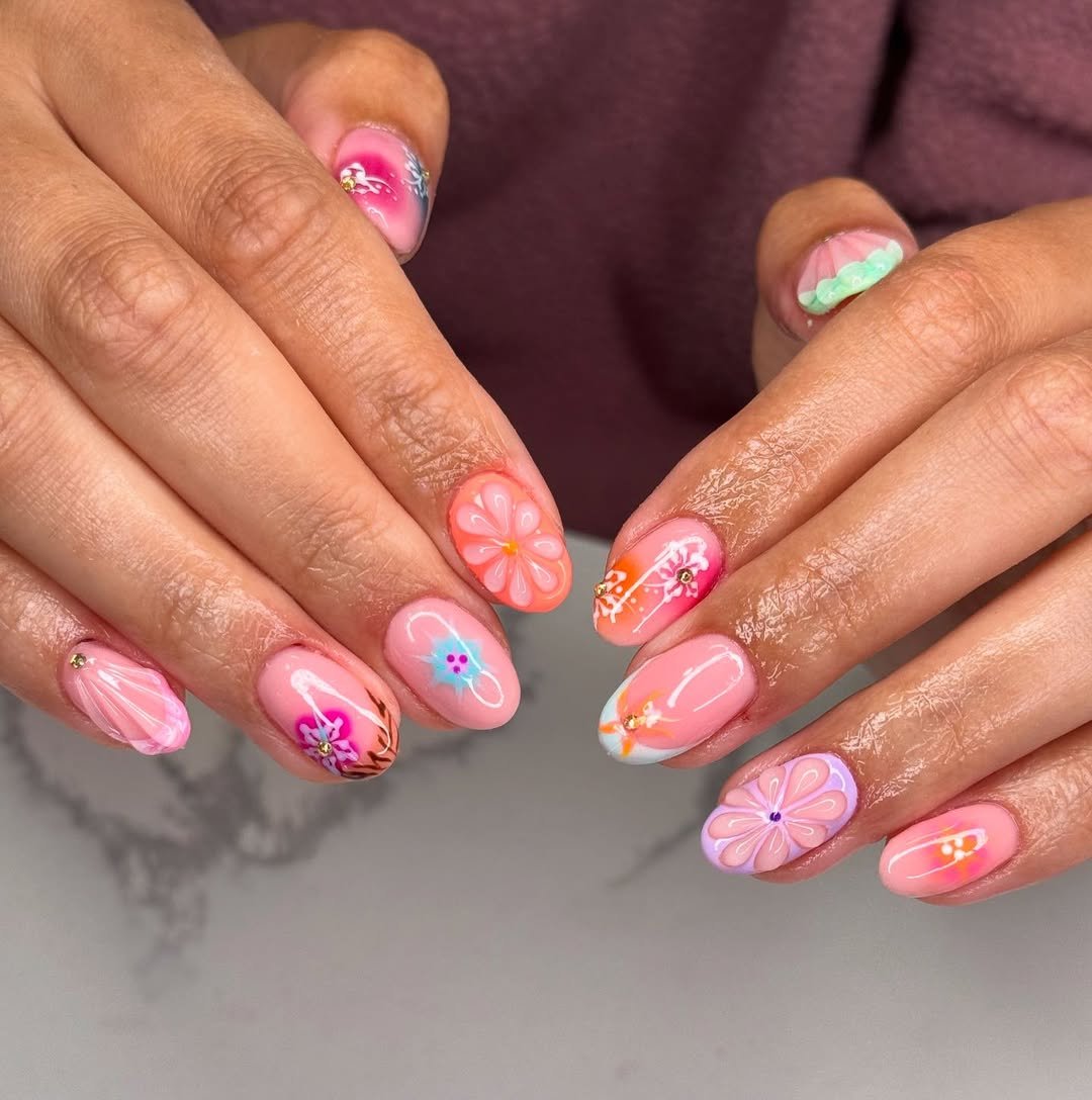 Nails with bright floral designs, abstract shapes, and gems